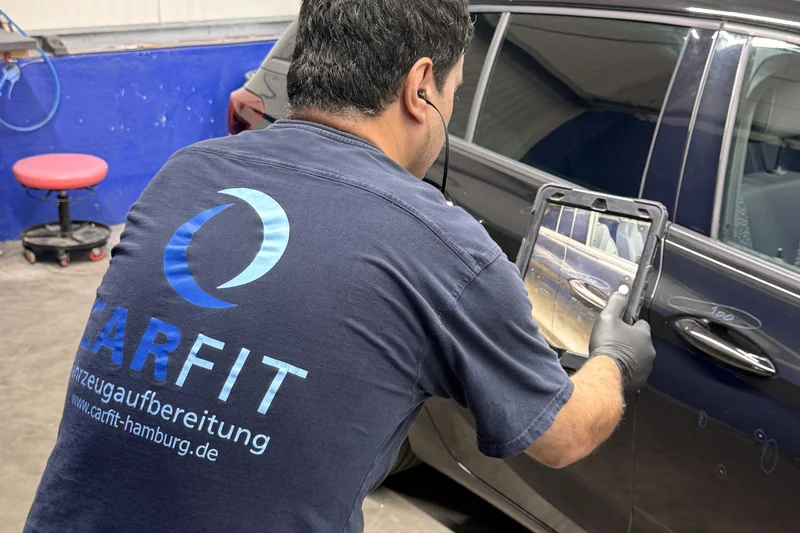 CARFIT Mitarbeiter dokumentiert ein Leasingfahrzeug mit dem Tablet